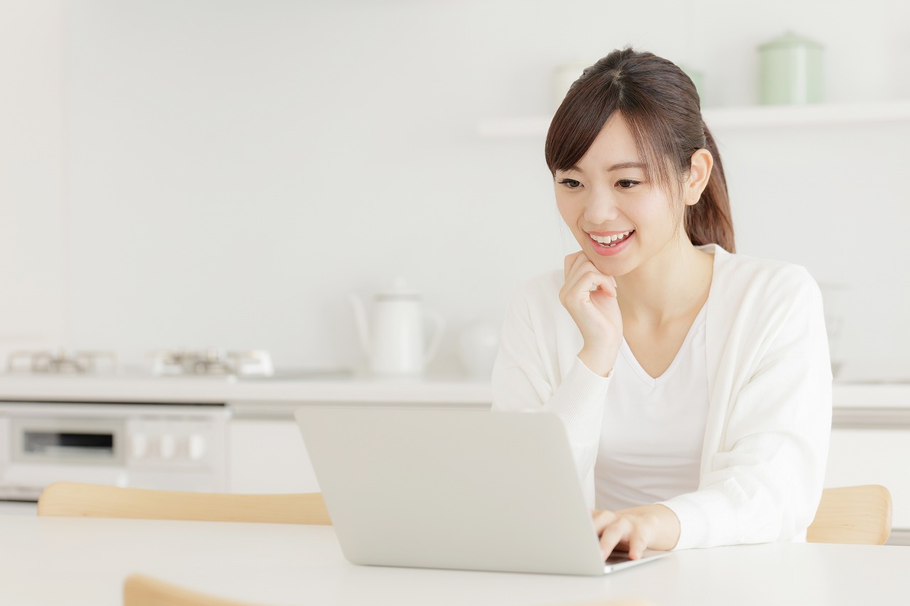 PCを笑顔で眺める女性